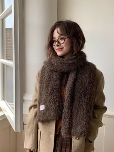 Detail of dark brown faux fur scarf with soft texture and minimalist woven label