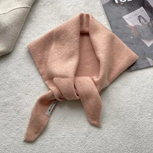 Détail de l'écharpe en maille rose avec texture douce et étiquette sur un fond élégant