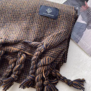 Détail de l'écharpe à carreaux bleu marine et marron avec franges et étiquette tissée