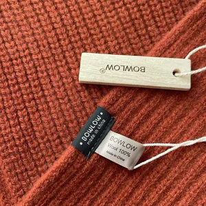 Detailaufnahme des 100% Woll-Strickschals mit Markenschild und Rippenstruktur