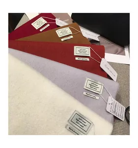Dettaglio di sciarpe in 100% lana in vari colori tra cui bordeaux e beige