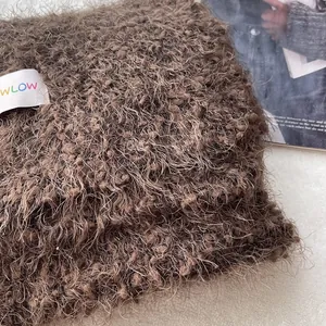 Detailed macro view of the dark brown fluffy wool scarf texture and white WLOW logo tag