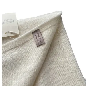 Premium 100% pure wool scarf in off-white featuring a minimalist knitted texture and tag