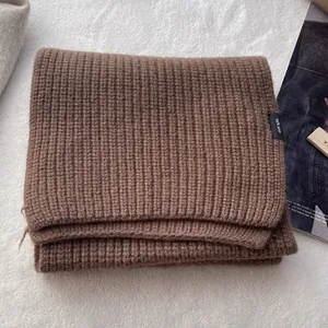 Nahaufnahme eines dunkelbraunen Schals aus 100% Wolle mit klassischer Rippstrickstruktur