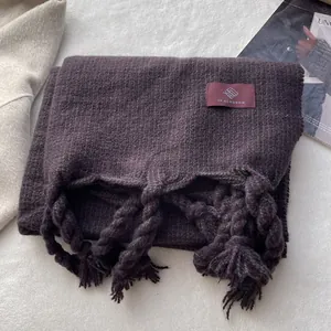 Détail d'une écharpe à carreaux épaisse avec texture tricotée violette et verte
