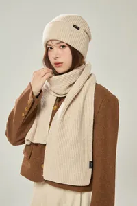 Detail des 100% Wolle Etiketts am beigefarbenen Rippstrick-Schal und Beanie-Set
