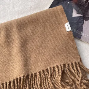Close-up of 100% pure wool camel scarf featuring a soft woven texture and fringe detail