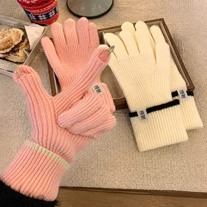 Mitaines thermiques en tricot rose et beige avec texture côtelée et écusson de la marque