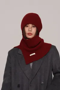 Detail of red wool balaclava with stitched 100% wool label worn by a model in grey coat