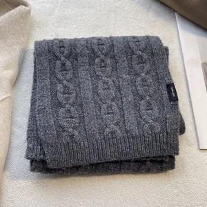 Detail of dark grey 100% wool scarf with cable knit texture and ribbed edge finish