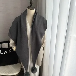 Écharpe d'hiver en tricot gris foncé avec pompons doux en fausse fourrure