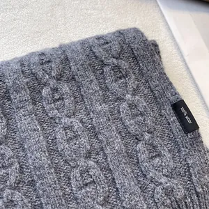 Close-up of thick 100% pure wool knitted scarf with a detailed cable pattern texture