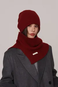 Detail of 100% wool knitted set with beanie and neck gaiter in deep red textured finish