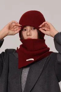 Detail of red knitted 100% wool hat and neck warmer showing the authentic wool label