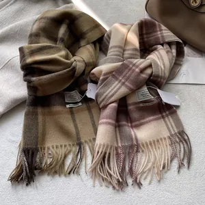 Detailopname van 100% wollen sjaals met ruitpatronen en handgemaakte franje aan de rand