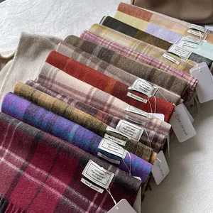Classic 100% wool scarves in various colorful plaid patterns stacked for soft texture display