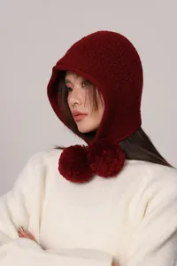 Dettaglio del passamontagna in lana bordeaux con pompon decorativi per l'inverno