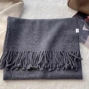 Detailed macro view of 100% pure wool scarf texture with elegant fringe and wash label