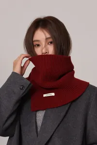Detail of 100% pure wool label on a deep red ribbed knit neck warmer for winter