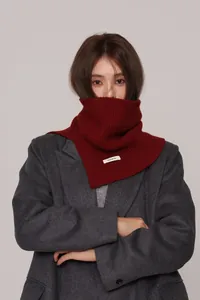 Detailed macro view of burgundy 100% wool ribbed knit neck warmer on a grey wool coat