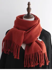 Detailed close-up of 100% pure wool scarf with soft tassels and woven texture label
