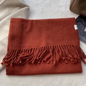 Close-up of 100% pure wool scarf in caramel brown with soft thick fringe texture