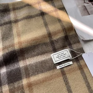 Detailopname van geruite wollen sjaal textuur met labels van 100% zachte wol vezels
