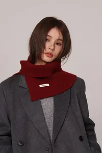 Detail of 100% wool burgundy knit neck warmer with ribbed texture on gray coat