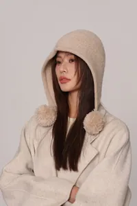Dettaglio della trama del passamontagna in maglia 100% lana beige con pompon soffici