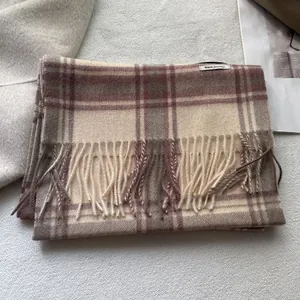 Detailopname van de geruite wollen sjaal met elegante franjes en zachte retro texturen