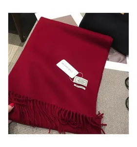 Dettaglio della sciarpa in 100% lana rossa con eleganti decorazioni a frange