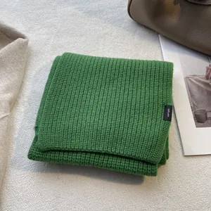 Detailaufnahme von grünem Wollschal aus 100% Wolle mit weicher Rippstrick-Struktur
