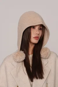 Dettaglio del passamontagna in maglia di lana con pompon in ecopelliccia beige