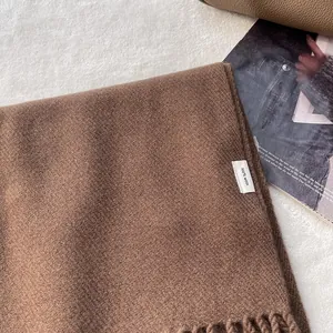 Close-up of brown 100% wool scarf texture with classic fringed edge details