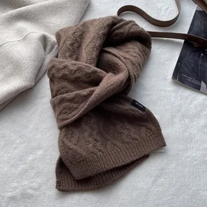 Detailed macro view of 100% Merino wool knitted scarf with dark brown cable knit texture