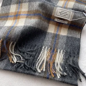 Close-up of 100% Australian wool scarf featuring grey-blue plaid texture and fringe details