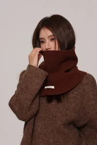 Detail of dark brown 100% wool ribbed knit turtleneck collar showing fabric texture
