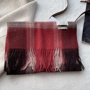 Macro detail of classic plaid 100% wool scarf texture with soft fringed edges