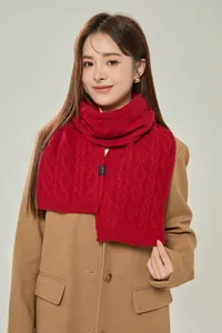 Detail of red cable-knit 100% merino wool scarf with premium texture for winter