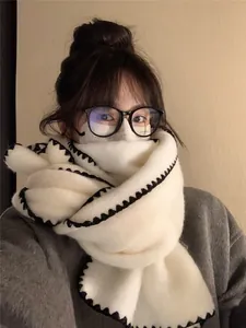 Close-up of thick off-white wool scarf with black crochet scalloped edge stitching