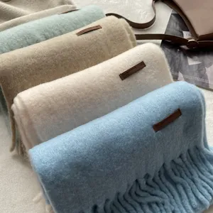 Detailed shot of assorted cashmere-feel scarves with fringe and leather tags