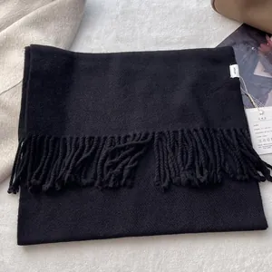 Detail shot of black 100% pure wool scarf with fringe and quality certification tag