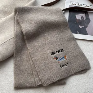 Brown knitted scarf with dachshund embroidery and ONE BAGEL text for winter warmth
