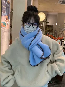 Close-up of light blue wool scarf with contrasting brown wavy stitched edges for winter