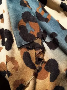 Close-up of thick leopard print scarf showing soft cashmere-like texture and fringed edges