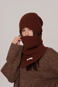 Detailed view of the dark brown knitted wool hat and matching neck warmer with 100% wool tag