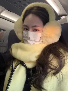 Detail of plush yellow earmuffs and matching scarf with black stitching for winter warmth