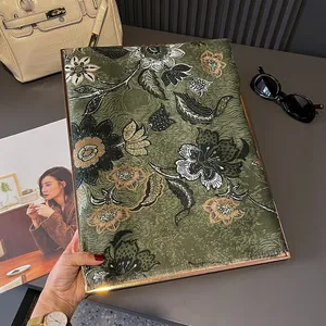 Dark green floral scarf with cotton-linen feel and fine tassels displayed with accessories
