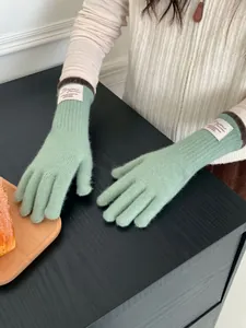 Dettaglio guanti in maglia verde menta con etichetta Bonjour e polsini marroni