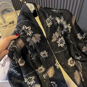Detailed shot of floral print scarf with silk texture draped over a white luxury handbag